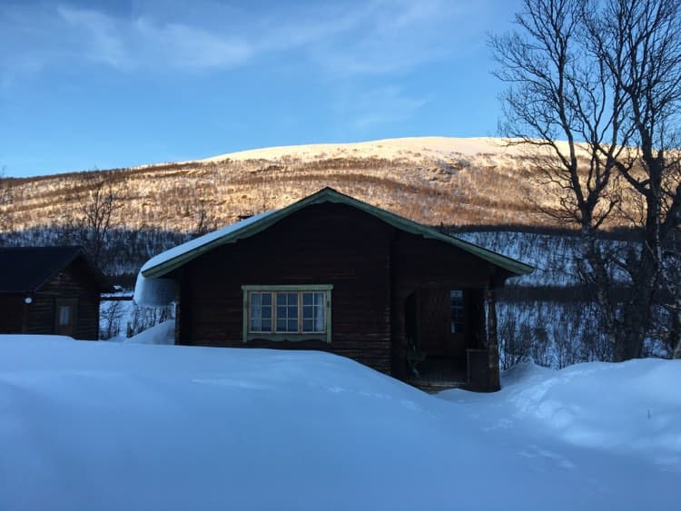 The bigger cabin covered in snow